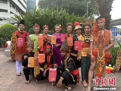 15日晚，马来西亚百年老街茨厂街举行老街走月活动，庆祝中秋节和即将到来的马来西亚日。图为马来裔青年男女也穿上民族服装，提上灯笼共同参与。 陈悦 摄
