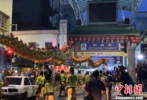15日晚，马来西亚百年老街茨厂街举行老街走月活动，庆祝中秋节和即将到来的马来西亚日。图为巡游队伍在茨厂街口舞龙。陈悦 摄 