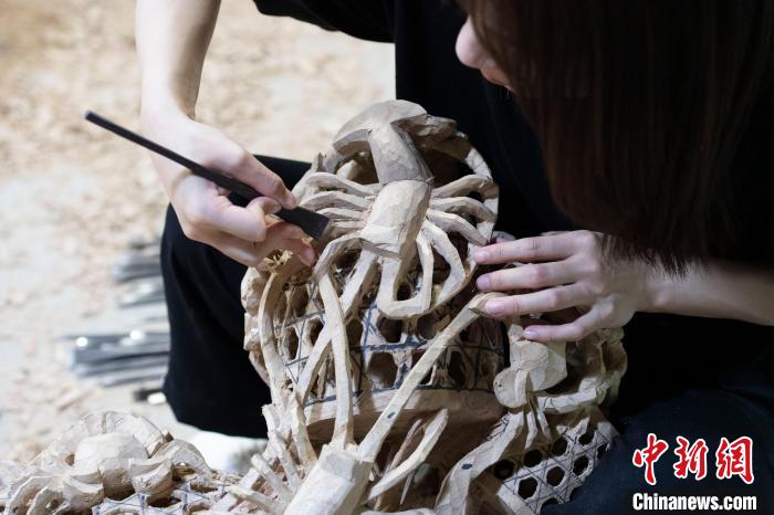 图为陈嘉正在用刻刀雕刻龙虾脚 陈楚红 摄