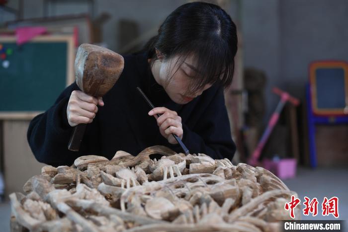 图为陈嘉用刻刀和木锤做精细部分 陈楚红 摄
