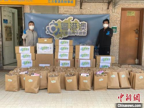 中国侨网图为粤港澳大湾区青年总会主席吴学明（右）与副主席张弘（左）搬运多箱抗疫防疫物资到疫区。　受访者供图