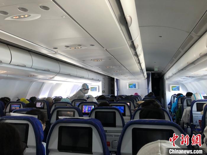 航班上，身着防护服的南方航空空姐在服务。　何乐(通讯员) 摄