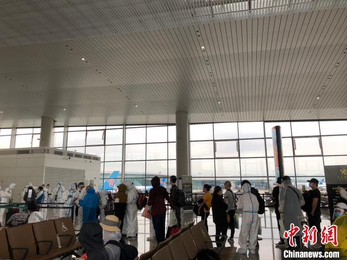 安抵广州的同胞，在排队等候接受体检。　何乐(通讯员) 摄