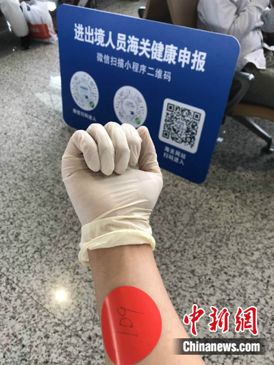 抵达广州的同胞，编号排队进行体检。然后进入十四天的隔离居住观察期。作者：何乐（通讯员）