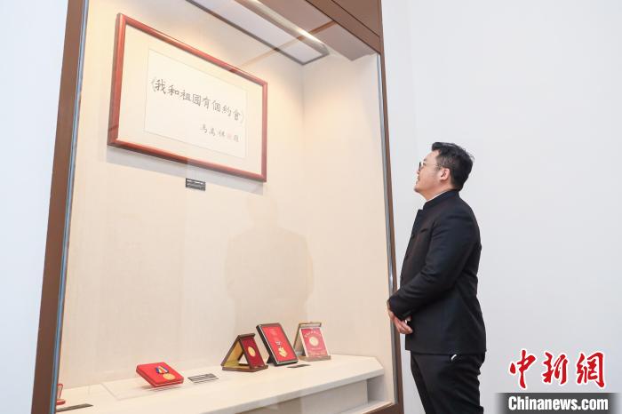 马志达仰望爷爷马万祺题写的片名《我和祖国有个约会》。　广州外宣办供图
