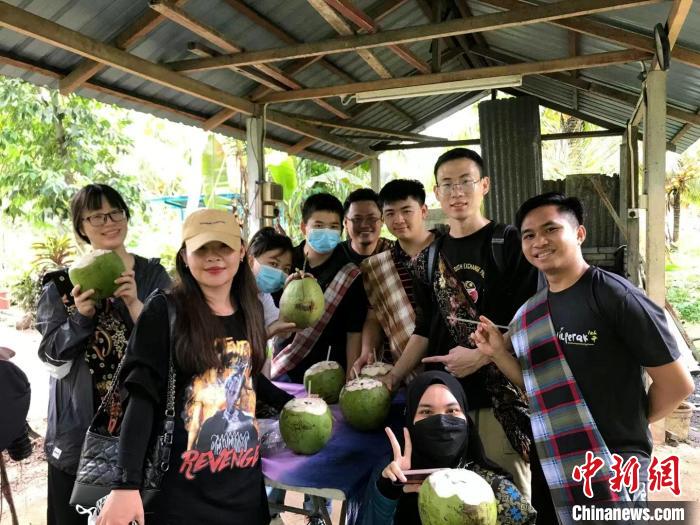 同学们走入马来乡区，一起喝着清凉的椰子水 主办方供图