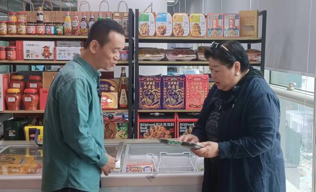 中国新加坡商会广东办事处副会长李懿静（右）和广州雪印食品股份有限公司总经理李煌（左）交流