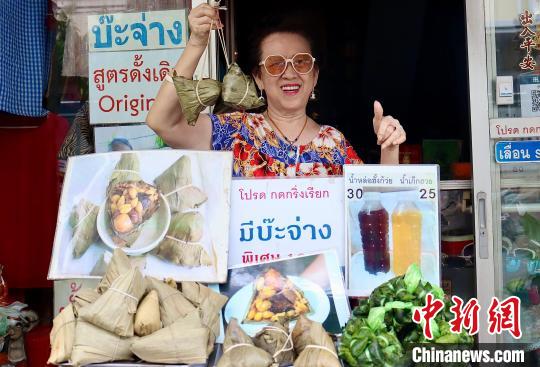 中国侨网蔡静华在店门口推介她的粽子。中新社发  王贤思摄