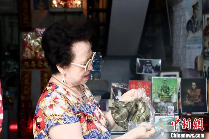 蔡静华向记者介绍粽子的制作技艺。<a target='_blank' href='//www.chinanews.com/'>中新社</a>发 王贤思 摄