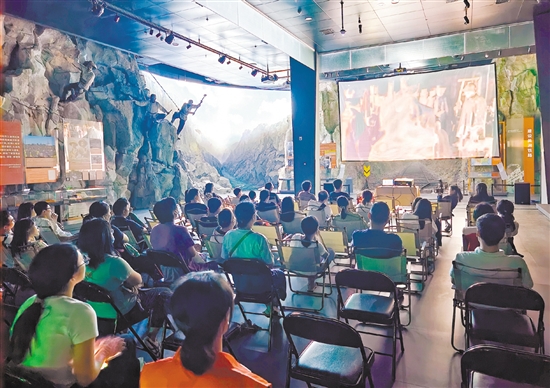 市民在侨博馆“拼搏海外”展厅里观看电影《金山》，了解华工修建太平洋铁路的故事。
