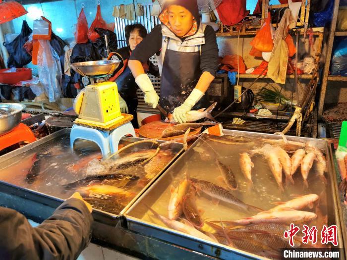 冬至当天水产档老板忙于对顾客选购的鲮鱼进行“起肉”处理 李晓春 摄