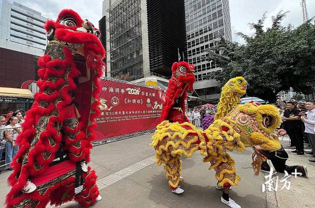 巴西圣保罗市街头，人们观看舞狮表演。