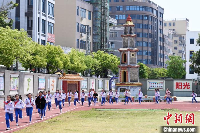 中国侨网4月7日，广东省汕头市澄海龙田学校的学生在文明塔前上体育课。文明塔为澄海市重点文物保护单位，至今将近450年历史。该塔建成后，龙田乡里人才辈出，文风浓厚。1994年，文明塔被围入龙田学校园内，祈求一乡文运昌盛。中新社记者 陈楚红 摄　