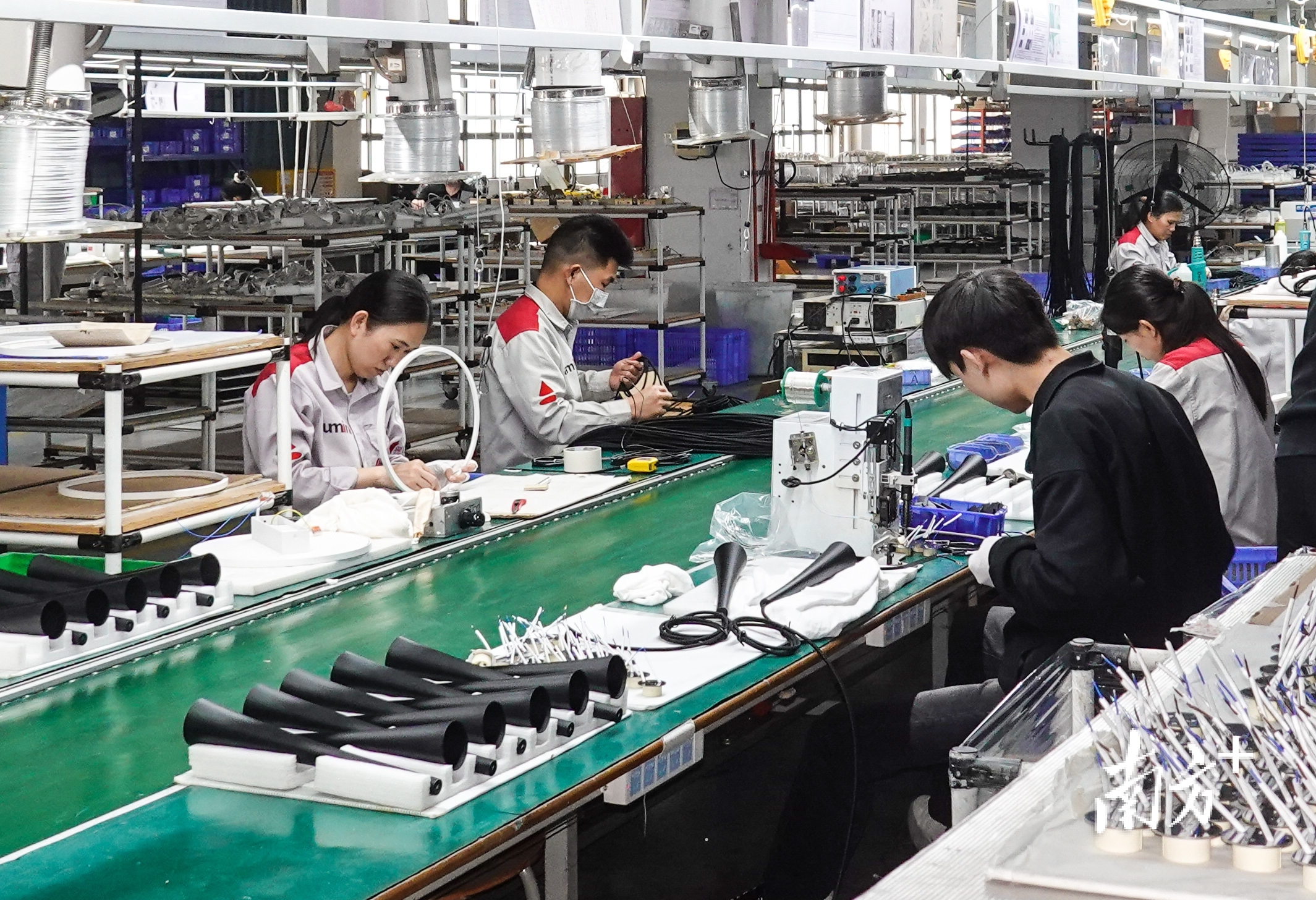 在中山市阿鲁米尼照明有限公司车间内,工人正在进行装配作业。