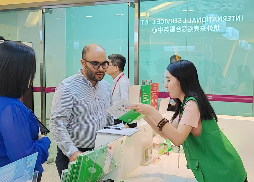 深圳机场工作人员为入境旅客提供服务指引。深圳机场供图