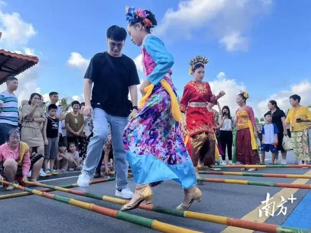 在海宴镇五丰村,东盟国家在粤留学生与归侨后人同跳竹竿舞。